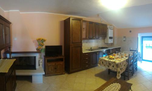 a kitchen with a table and a kitchen with a tableablish at B&B Il Fratino in Pescocostanzo