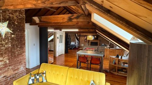 a living room with a yellow couch and a kitchen at Townhouse in Portsmouth Downtown Historic District in Portsmouth