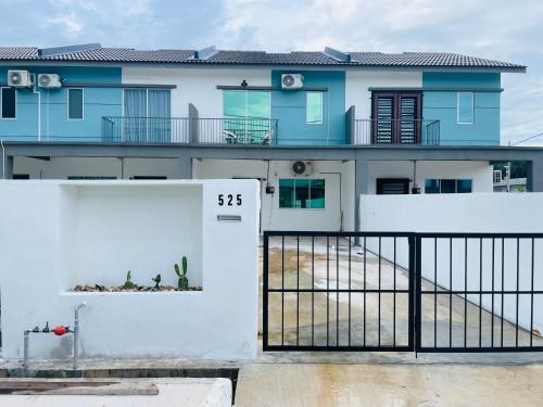 ein blau-weißes Haus mit einem weißen Zaun in der Unterkunft NAZS Homestay sungai petani in Sungai Petani