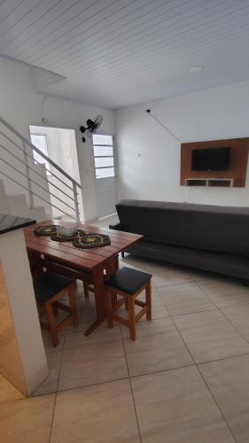 a living room with a wooden table and a couch at Casa na Guilhermina 500mt da praia in Praia Grande