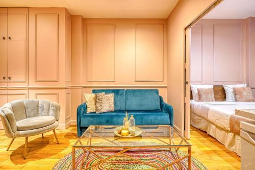 ein Wohnzimmer mit einem blauen Sofa und einem Sessel in der Unterkunft Suite Anna In Paris Republique in Paris