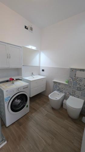 a bathroom with a washing machine and a toilet at Casetta Belvedere in Valle San Nicolao