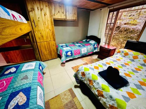 ein Schlafzimmer mit zwei Betten und einem Etagenbett in der Unterkunft Cabaña Campestre Renacer in Paipa