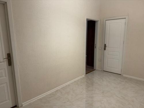 une pièce vide avec des murs blancs et une porte dans l'établissement Sumqait Baxchasheher Center, à Soumgaït
