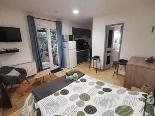 a living room with a bed and a kitchen with a kitchen at Studio Le Yuka entre Mer et Montagne in Villelongue-dels-Monts