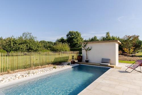 a swimming pool in a backyard with a fence at Villa, piscine chauffée, aux portes de Lyon in Sainte-Euphémie