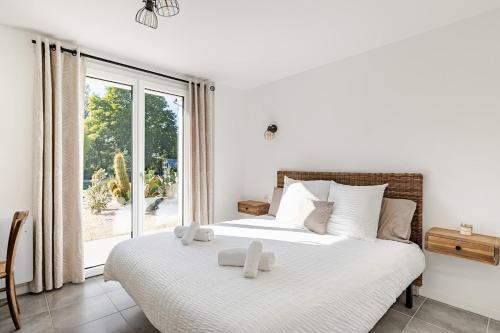 a bedroom with a bed with white sheets and a window at Villa, piscine chauffée, aux portes de Lyon in Sainte-Euphémie