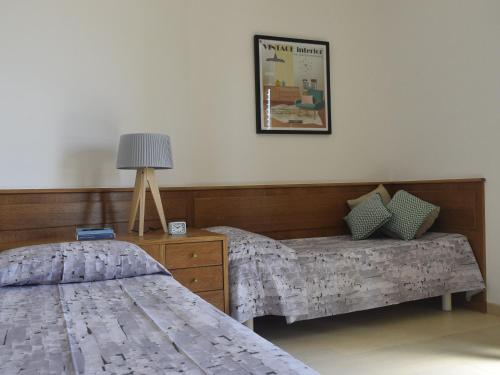1 dormitorio con 2 camas y mesa con lámpara en My Loft in Naples, en Nápoles