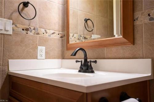 un baño con lavabo y espejo en 4182 Thistle cir, en Virginia Beach