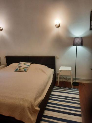 a bedroom with a bed and a lamp and a rug at Stylish 2BR in Old Town Gem in Riga