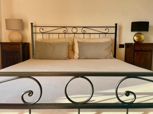 a bed with a metal frame and two pillows at Casa Di Gloria in Perledo