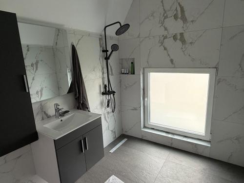 a white bathroom with a sink and a window at Villa Marina in Novoberdo