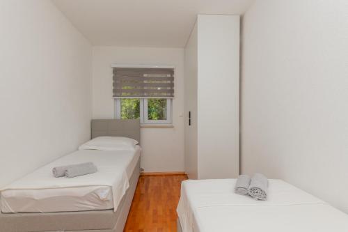 due letti in una stanza con pareti bianche e una finestra di Villa Josip a Grubine