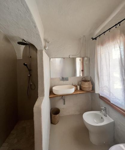 a white bathroom with a sink and a toilet at DomoMea Porto Cervo in Abbiadori