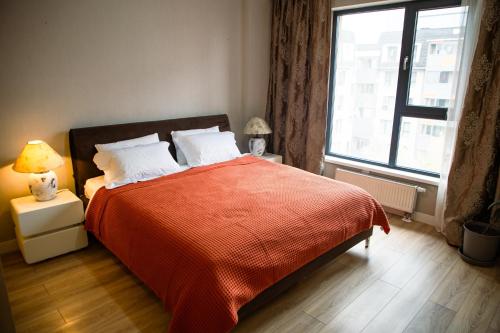 une chambre avec un lit avec une couverture rouge et une fenêtre dans l'établissement Modern, Luxury 3BR near Airport, PS4 Fast Wi-fi, Workstation, à ULN