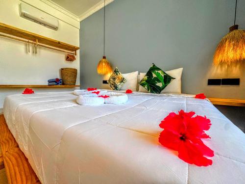 a large white bed with a red flower on it at Marea Boutique Hotel in Jambiani