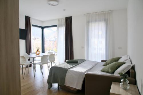 蒂拉诺Bernina Suites - vicino al Bernina Express的一间带大床的卧室和一间餐厅