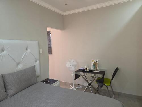 Lolly's Piece of Home في خليج ريتشاردز: غرفة نوم بسرير ومكتب مع طاولة