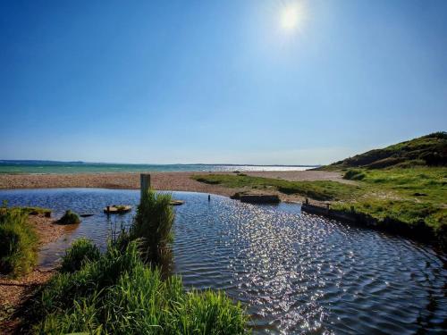 a body of water next to a sandy beach at Cabin 100 in Warsash