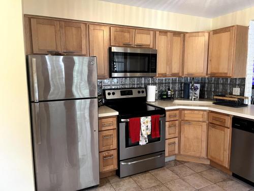 eine Küche mit Küchengeräten aus Edelstahl und Holzschränken in der Unterkunft Zen Den Beach House Bungalow in St Petersburg