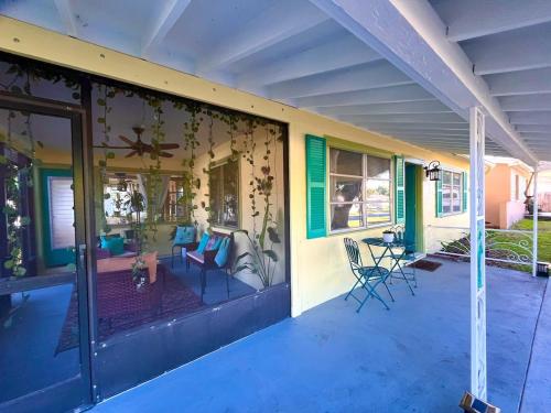 ein Haus mit einer abgeschirmten Veranda mit einer Terrasse in der Unterkunft Zen Den Beach House Bungalow in St Petersburg