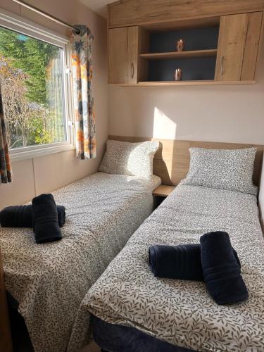 two beds sitting next to each other in a bedroom at Cabin 100 in Warsash