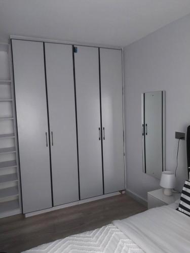 una camera con 4 armadi bianchi e un letto di Empiris Luxe Homes a Narok