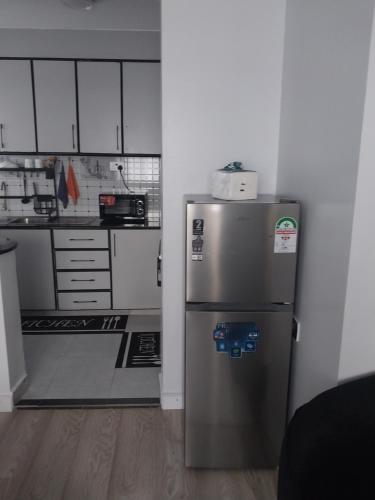 una cucina con frigorifero in acciaio inossidabile e mobili bianchi di Empiris Luxe Homes a Narok