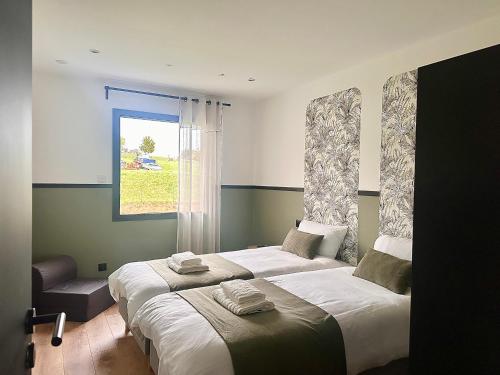 ein Schlafzimmer mit zwei Betten und einem Fenster in der Unterkunft Escale Doullennaise - Appartement neuf avec terrasse in Doullens