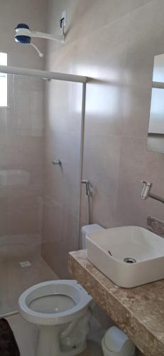 a bathroom with a toilet and a sink at Casa de Praia Nova, 3 quartos, 1 Suíte, com quintal privativo, em condomínio, muito bem Localizado in Porto Seguro