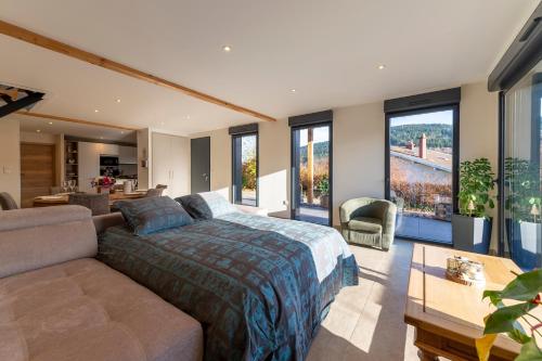 een slaapkamer met een bed en een bank bij Charmant chalet, spacieux, proche du lac, vue sur la montagne in Gérardmer