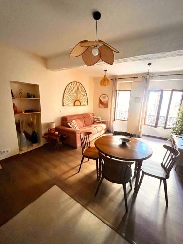 een woonkamer met een tafel en een bank bij Studio L'oasis Ensoleillé in Cuers