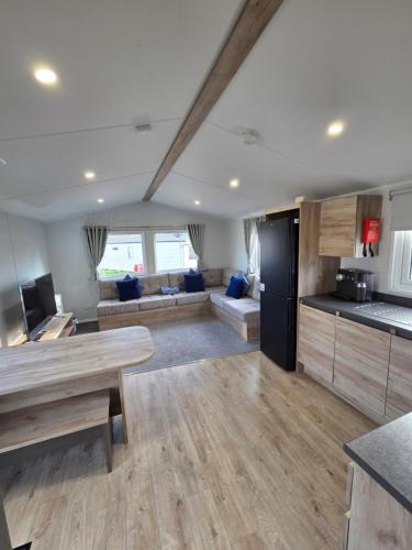 a kitchen and living room with a table and a couch at 8 Berth Caravan Haven Marton Mere in Blackpool