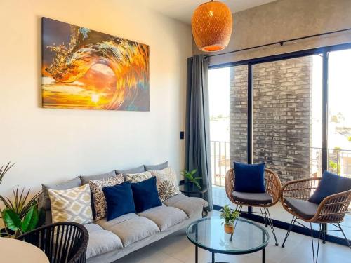 Apartment for 7 people with pool on the 3rd floor في Isla Venados: غرفة معيشة مع أريكة ولوحة على الحائط