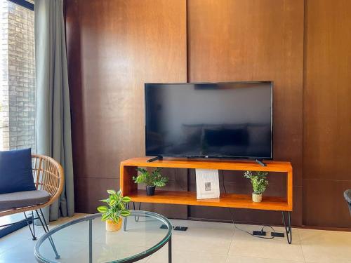 Apartment for 7 people with pool on the 3rd floor في Isla Venados: تلفزيون بشاشة مسطحة جالس فوق مركز ترفيهي خشبي