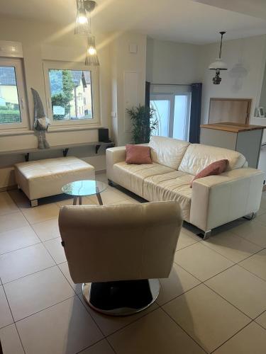 ein Wohnzimmer mit einer Couch und einem Sessel in der Unterkunft Gite le Mamama, maison cosy au centre du village in Sommerau