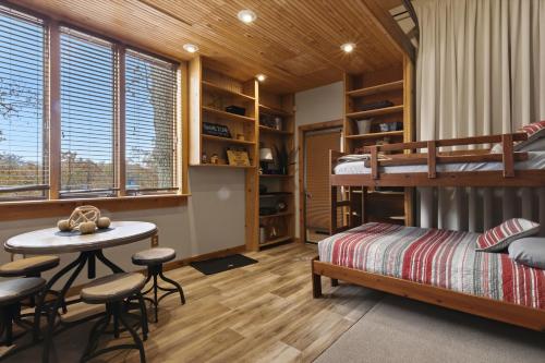 ein Schlafzimmer mit einem Etagenbett, einem Tisch und Stühlen in der Unterkunft Game Room, Dock Life, Fire Pit & Hot Tub! in Four Seasons