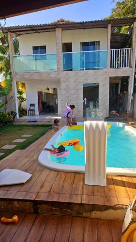 une terrasse de piscine avec une table et des chaises et une maison dans l'établissement Casa Barra do Jacuípe, à Camaçari