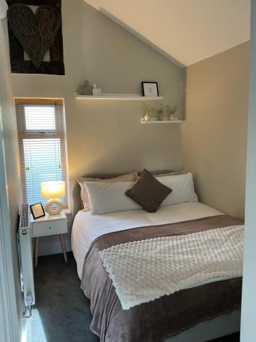 a bedroom with a bed and a window at Towneley Lodge, Burnley in Burnley
