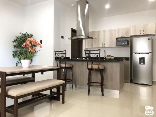 Una cocina con mesa y sillas y un refrigerador. en Apartment with pool 3 blocks from the beach, en Isla Venados