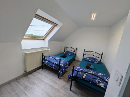 White house between land and sea St Pol de Léon في بلدة سان-بول-دو-ليون: سريرين توأم في غرفة بها نافذة