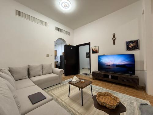 a living room with a couch and a flat screen tv at Modern Studio Private in Abu Dhabi