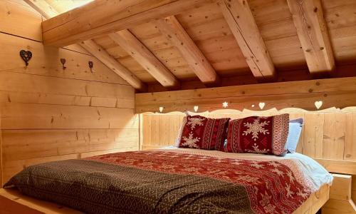 a bedroom with a bed in a log cabin at Alpen Lounge in Servoz