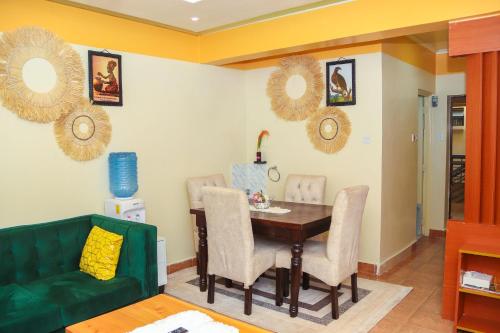 comedor con mesa y sofá verde en Welcome to Splendid Suites, en Syokimau