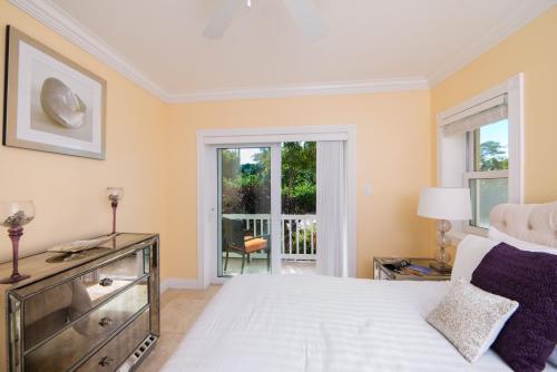 sypialnia z białym łóżkiem i oknem w obiekcie The Hamilton Beach Villas & Spa w mieście Nevis