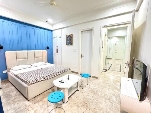 a bedroom with a bed and a tv and a bathroom at The Olivia -Luxury Apartments in Rishīkesh