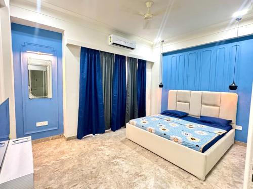 a bedroom with blue walls and a bed in it at The Olivia -Luxury Apartments in Rishīkesh