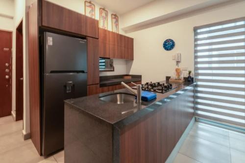 eine Küche mit einer Spüle und einem schwarzen Kühlschrank in der Unterkunft Apartment for 6 on the first floor with pool in Los Cerritos