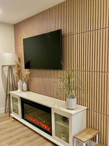 a living room with a flat screen tv on a wall at Low Tide Suite - Modern, Oceanside Suite with King Bed, Resort Pool & Hot Tub in Nanoose Bay