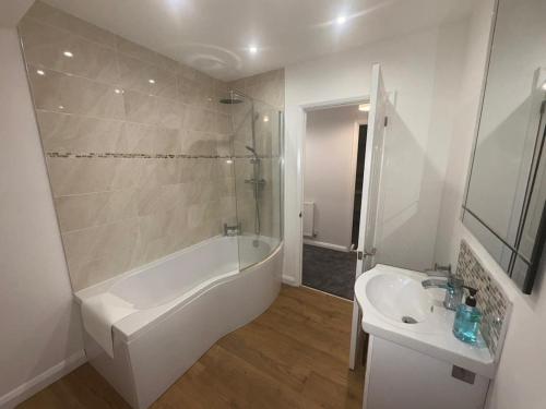a white bathroom with a tub and a sink at Large 4 bedroom Family let, Contractor, Corporate in Market Harborough